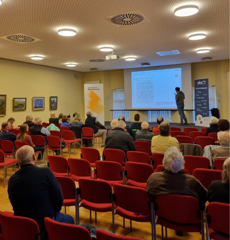 Blick zur Bühne während der dritten Veranstaltung „Auf der Suche“ zum biographischen Forschen, 01. April 2025. Foto: Julia Landau.